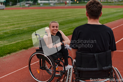 Image of A woman with disability in a wheelchair talking with friend after training on the marathon course