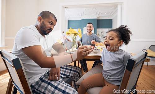 Image of Gay couple, breakfast and father feeding child meal, food or morning cereal for youth development in home dining room. Family bond, adoption or homosexual dad smile for hungry kid girl eating