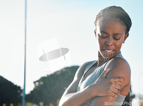 Image of Fitness, running and a black woman with pain in arm from outdoor exercise, training and field sports. Accident, young and an African athlete with a muscle injury from a workout, cardio or emergency