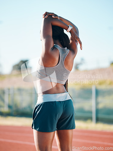 Image of Stretching, sports and exercise with a woman outdoor on a track for running, training or workout. Behind African athlete person at stadium for arm stretch, fitness and muscle warm up or body wellness