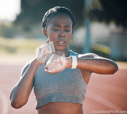 Image of Time, pulse and exercise with a woman outdoor on a track for running, training or workout. African athlete person at stadium for goals, fitness and body wellness with a watch for progress or steps