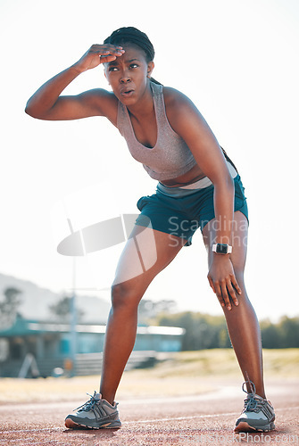 Image of Sweating, tired and black woman at stadium for a race, training or breathing after cardio. Sports, workout and an athlete or African runner with a break after fitness, running or exercise on a track