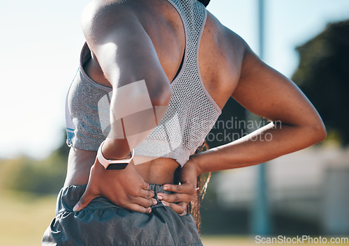 Image of Back pain, fitness and athlete with injury problem in a stadium due to outdoor exercise, training or workout. Hurt, inflammation and person with muscle strain, ache or body tension by the spine