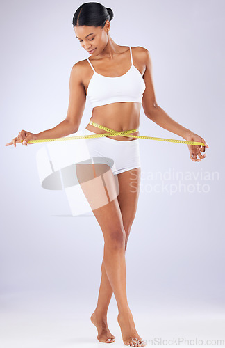 Image of Fitness, body and progress with woman and tape in studio for weight loss, detox and workout. Wellness, diet and health with person on white background for results, cosmetics and goal measurement