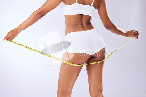 Image of Fitness, butt and health with woman and tape in studio for weight loss, detox and workout. Wellness, diet and progress with closeup of person on white background for results, cosmetics or measurement