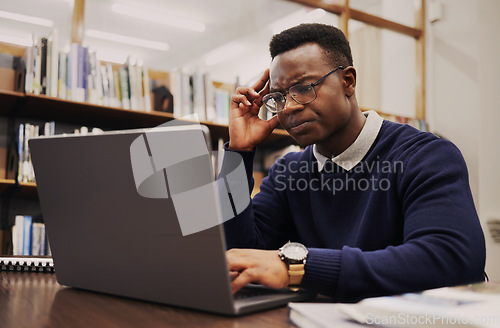 Image of Man, student and thinking on laptop in library for studying, university research or headache and stress of debt or results. Young and confused african person on computer for education FAQ or question