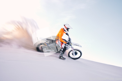 Image of Bike, dust and motion blur with a sports man riding a vehicle in the desert for adventure or adrenaline. Motorcycle, training and speed with an athlete on sand in nature for speed, freedom or energy