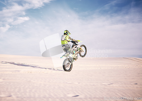 Image of Bike, space and balance with a sports man riding a vehicle in the desert for adventure or adrenaline. Motorcycle, training or freedom and an athlete on sand in nature for skill or power with mockup