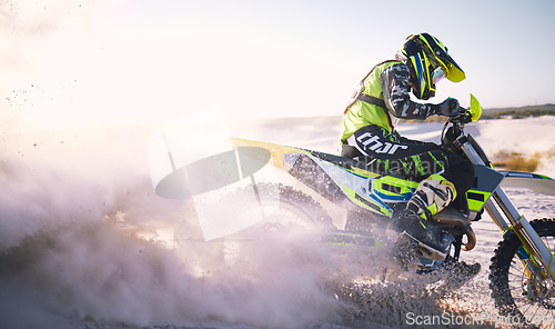 Image of Bike, sand and dust with a sports man riding a vehicle in the desert for adventure or adrenaline. Motorcycle, freedom and training at speed with an athlete outdoor in nature for power or competition