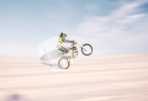 Image of Bike, speed and balance with a sports man riding a vehicle in the desert for adventure or adrenaline. Motorcycle, training and motion blur with an athlete outdoor in nature for freedom or power
