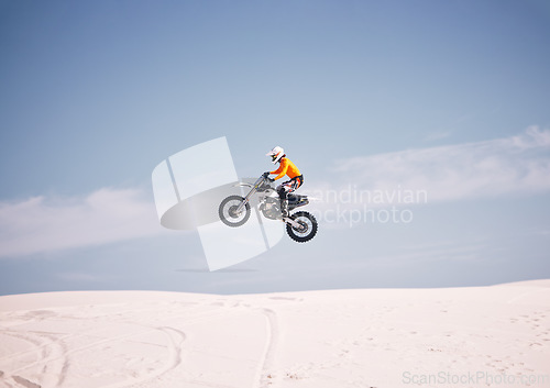 Image of Motorcycle, mockup and sky with a man in the desert riding a vehicle for adventure or adrenaline. Bike, jump and training with an athlete in the air in nature for freedom, power or active competition