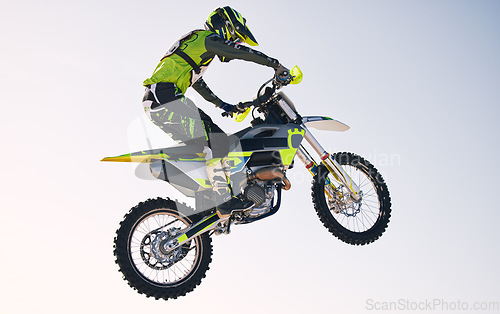 Image of Jump, adventure and man on motorbike with blue sky for practice, training and extreme sports energy. Professional dirt biking challenge, person and danger with off road motorcycle stunt competition.