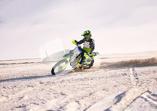 Image of Motorcycle, dust and speed with a sports man riding a vehicle in the desert for adventure or adrenaline. Bike, freedom and training on sand with an athlete outdoor in nature for power or competition