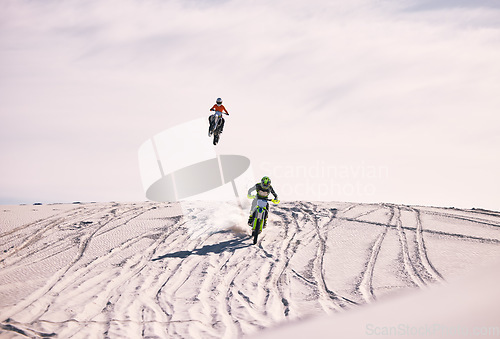 Image of Dune, jump and men in motorbike race together for practice, training and extreme sports energy. Professional dirt biking challenge, friends and danger with off road motorcycle competition in desert.