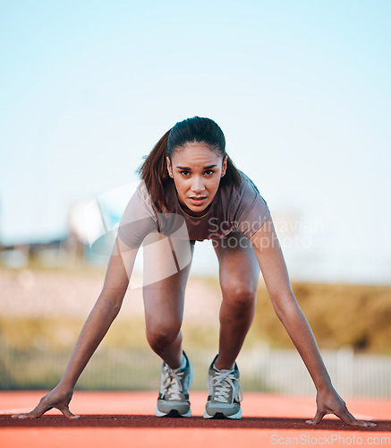 Image of Woman, portrait and start of running athlete in sports fitness, exercise or motivation on stadium track. Serious female person or runner ready in race, sprint marathon or cardio workout and training