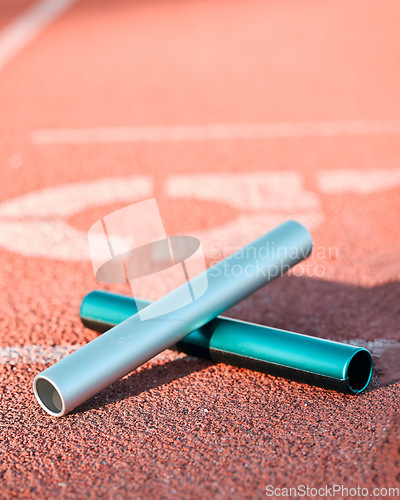 Image of Sports, track and closeup of baton in a stadium for a relay race, marathon or competition. Fitness, running and zoom of athletic equipment on the ground for cardio training, workout or exercise.