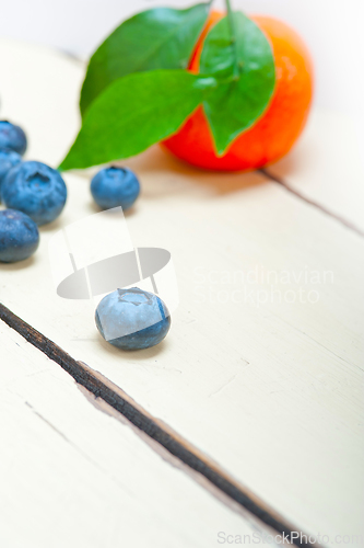 Image of tangerine and blueberry on white table