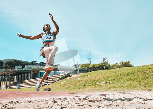 Image of Athletics, fitness and sports woman doing long jump in outdoor competition, athlete challenge or workout. Agility, sand pit and female person training, exercise and action performance at arena event