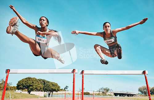 Image of Sports, hurdles and team of women on track running in a race, marathon or competition in stadium. Fitness, workout and female athletes jumping with speed and energy for outdoor training or practice.