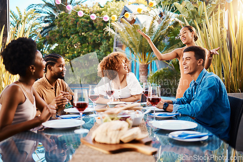 Image of Friends, food and eating outdoor at a table for social gathering, happiness and holiday celebration. Diversity, men and women group at lunch, party or reunion with drinks in garden for fun and relax