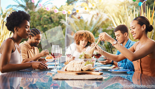 Image of Friends at lunch, party in garden and happy event with diversity, food and wine for bonding together. Outdoor dinner, men and women at table, group of people eating with drinks in backyard in summer.