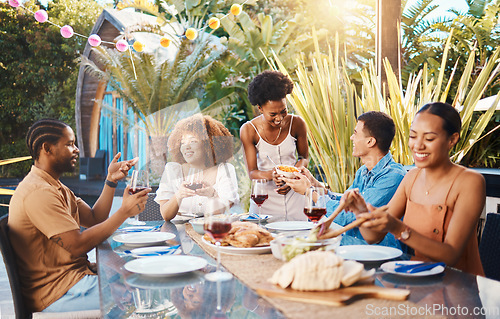 Image of Group of friends at lunch in garden and talking at happy event with diversity, food and wine. Outdoor dinner, men and women in conversation at table, people eating with drinks in backyard together.