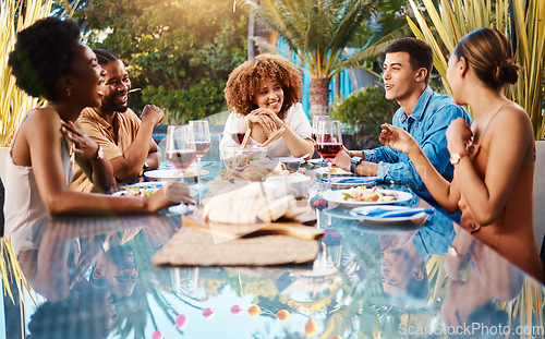 Image of Friends, food and outdoor table for holiday, Christmas or thanksgiving lunch and wine at backyard patio. Young people or social group with alcohol, brunch and drink or talking of summer vacation