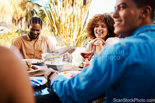 Image of Happy, friends and lunch in a garden together for conversation, eating and bonding at a table. Smile, laughing and diversity of a woman and men in a backyard with food, conversation or dinner