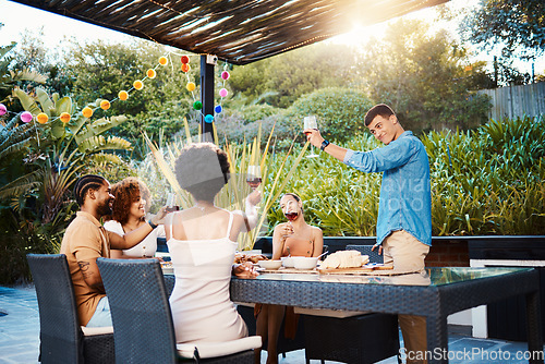 Image of Cheers, group of friends at dinner in garden at party and celebration with diversity, food and wine at outdoor party. Glass toast, men and women at table, fun people with drinks in backyard together.
