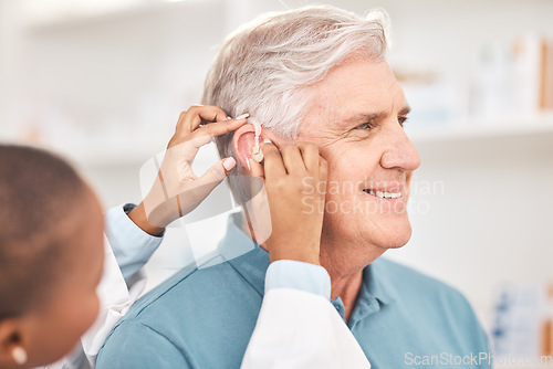 Image of Helping, man and doctor with hearing aid, technology or healthcare or medical device consultation for deaf patient with tinnitus. Listening, test and exam ear tech with nurse or senior male in clinic