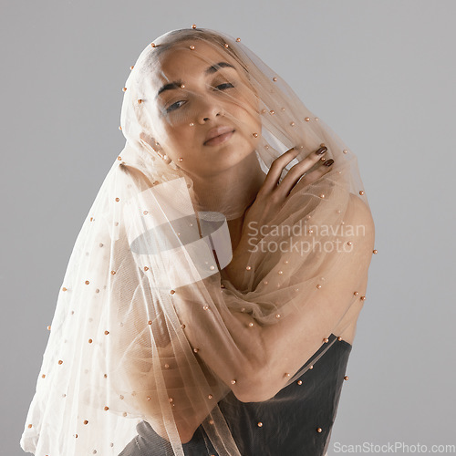 Image of Portrait, creative and a woman with a veil on a studio background for a wedding or aesthetic. Fashion, model and a young girl with clothes for creativity, elegant and classy isolated on a backdrop