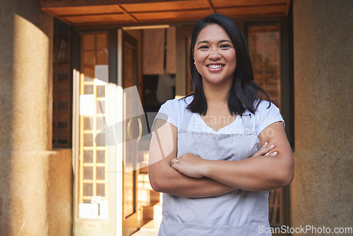 Image of Portrait, waitress and Asian woman with arms crossed at restaurant, coffee shop or store. Face, smile and confident barista, happy employee or small business entrepreneur at cafe startup in Cambodia