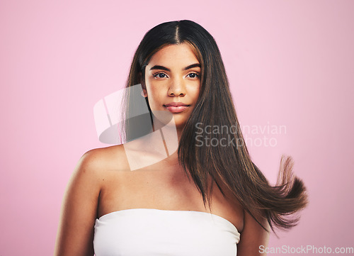 Image of Hair care, wind and woman portrait with natural beauty and salon treatment in a studio. Shampoo, cosmetics and Brazilian hairstyle with a female model from Brazil with confidence with pink background