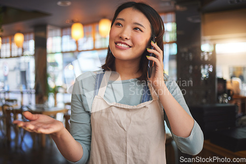 Image of Restaurant, phone call and Asian woman for online order, delivery and food service in cafeteria. Coffee shop, small business and happy waitress, cafe barista or manager on smartphone in discussion