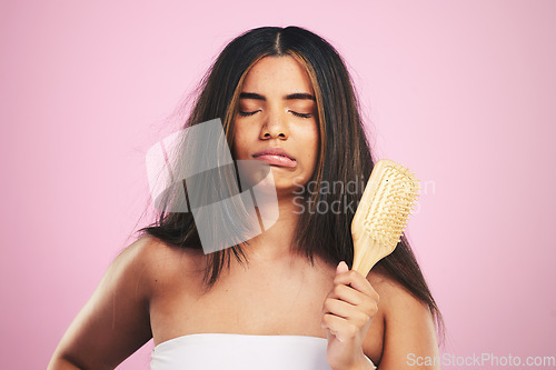 Image of Hair care, frustrated and woman with brush ready for salon beauty treatment in a studio. Brushing, upset and Brazilian hairstyle growth with female model from Brazil with problem and pink background