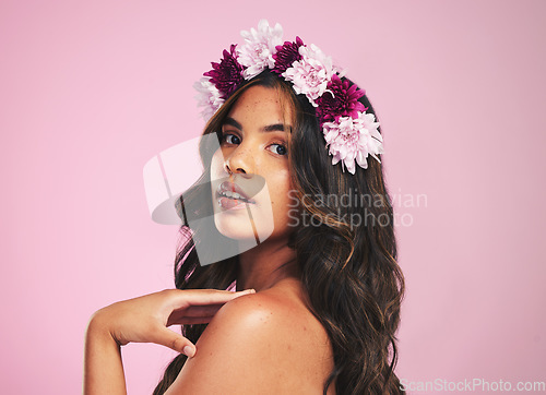 Image of Woman, flowers and portrait of crown in studio for beauty, natural skincare and spring plants on pink background. Face, model and floral wreath for sustainable cosmetics, eco dermatology or hair care