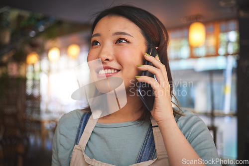 Image of Restaurant, phone call and Asian woman for order, delivery and online food service in cafeteria. Coffee shop, small business and happy waitress, cafe barista or manager on smartphone in discussion