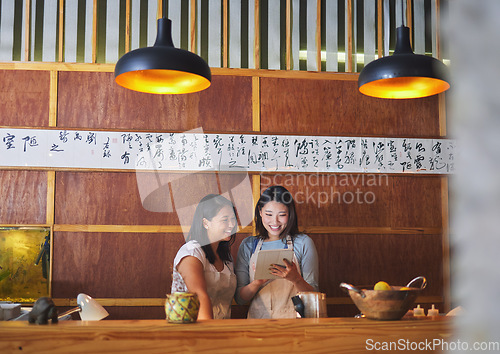 Image of Restaurant, tablet and asian women at counter together checking sales, booking or menu for small business. Social media, content marketing and startup cafe owner with waitress scroll on digital app.