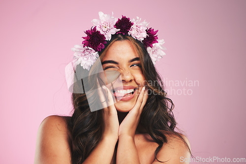 Image of Beauty, flowers and wink with hairstyle of woman in studio for cosmetics, skincare and wellness. Self care, spa treatment and crown with face of person on pink background for spring, glow and makeup