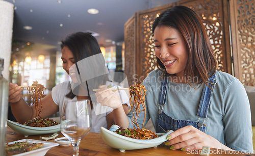 Image of Restaurant, girl friends and smile with food, noodles and cafe happy from bonding. Asian women, eating and plate together with friendship at a table hungry with chopsticks at Japanese bar gathering