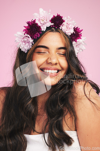 Image of Woman, flowers and smile with crown on pink background for natural beauty, skincare and self care in studio. Face, happy model and floral hair band for sustainability, eco dermatology and cosmetics