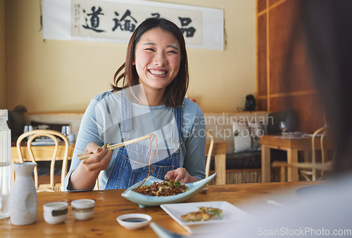 Image of Japanese, food and woman at a restaurant eating for dinner or lunch meal using chopsticks and feeling happy with smile. Plate, date and person enjoy Asian cuisine, noodles or diet at a table