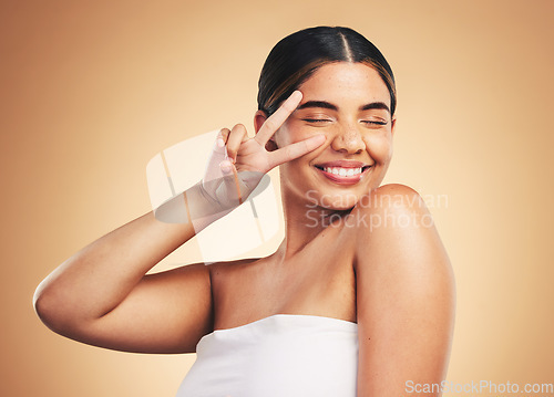 Image of Woman, beauty and skincare with peace sign, studio and cosmetics with natural glow on face by background. Girl, model and happy with icon, emoji or facial change with melasma, healthy shine and clean