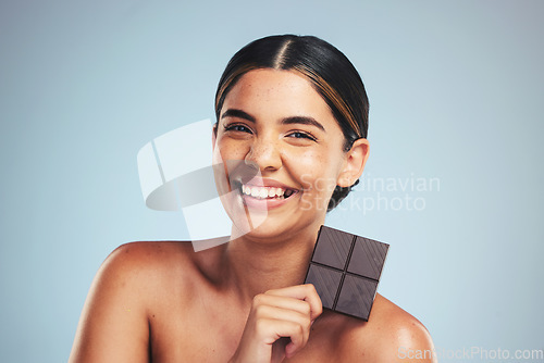 Image of Portrait, chocolate and happy woman in studio with diet, craving or unhealthy luxury snack on grey background. Face, smile and lady model with candy bar, sugar and cocoa, addiction or diet temptation