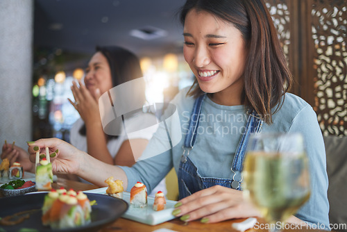 Image of Japanese woman, restaurant and eating sushi with smile, chopsticks and excited for fine dining at party. Asian friends, fish and healthy with culture, traditional or fast food in diner, bar or shop