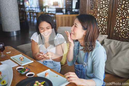 Image of Girl friends, sushi restaurant and eating together with comic laugh, joke and fail with chopsticks at table. Japanese women, happy and excited with fish, seafood or diner with help, mistake or memory