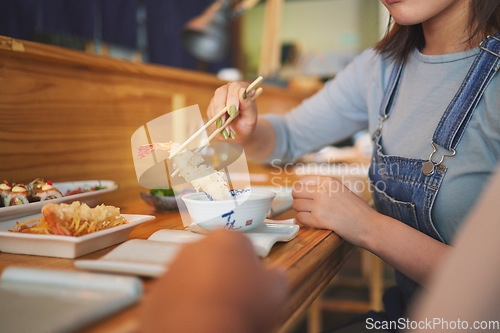 Image of Hands, chopsticks and woman with shrimp in restaurant, fine dining and eating in cafe store. Sushi, sticks and person on prawn, tempura food and fish meat in bowl for lunch, brunch and seafood meal