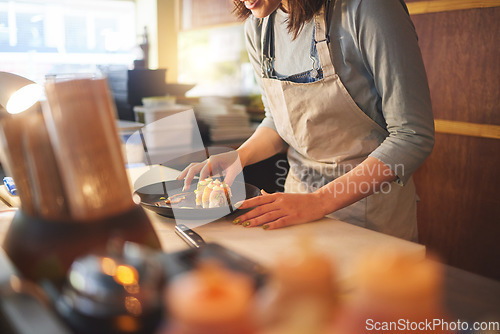 Image of Sushi chef, restaurant and ready in kitchen with hands, service or plate on table, job or catering. Small business, fast food and cooking in cafe, startup diner and working with fish, rice or seaweed