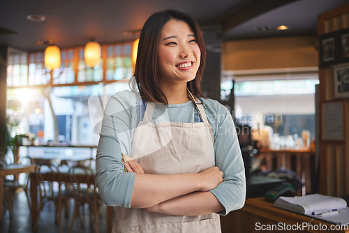 Image of Smile, thinking and arms crossed with an asian woman in a restaurant working as a waitress for service. Hospitality, happy and idea with a young employee in a chinese eatery for local cuisine