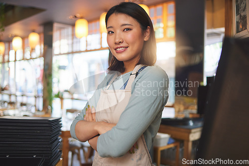 Image of Waitress, portrait and Asian woman with arms crossed at cafe, coffee shop or store. Face, smile and confident barista, happy employee or small business entrepreneur at restaurant startup in Japan